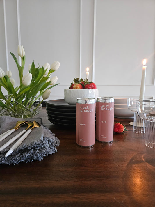 Dinner table styled for Valentine’s Day with Just Enough Wines rosé cans and fresh strawberries.