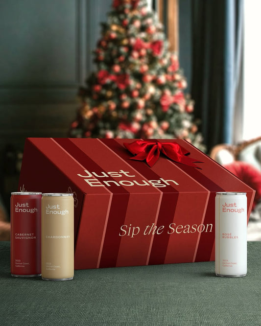 Just Enough’s limited-edition wine advent calendar displayed in front of a Christmas tree, with a few canned wines placed beside it.